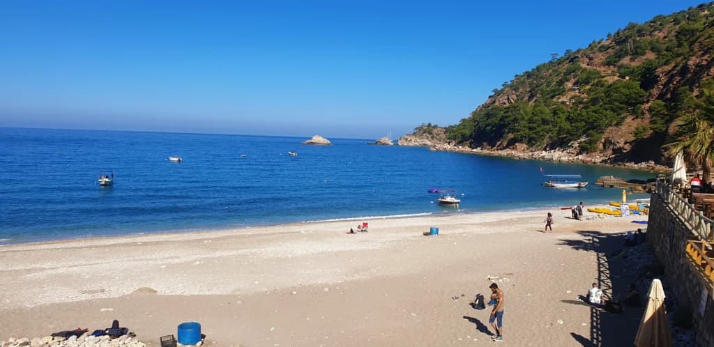 Kabak Bay beach near Butterfly Valley – rugged pebble shore surrounded by green hills